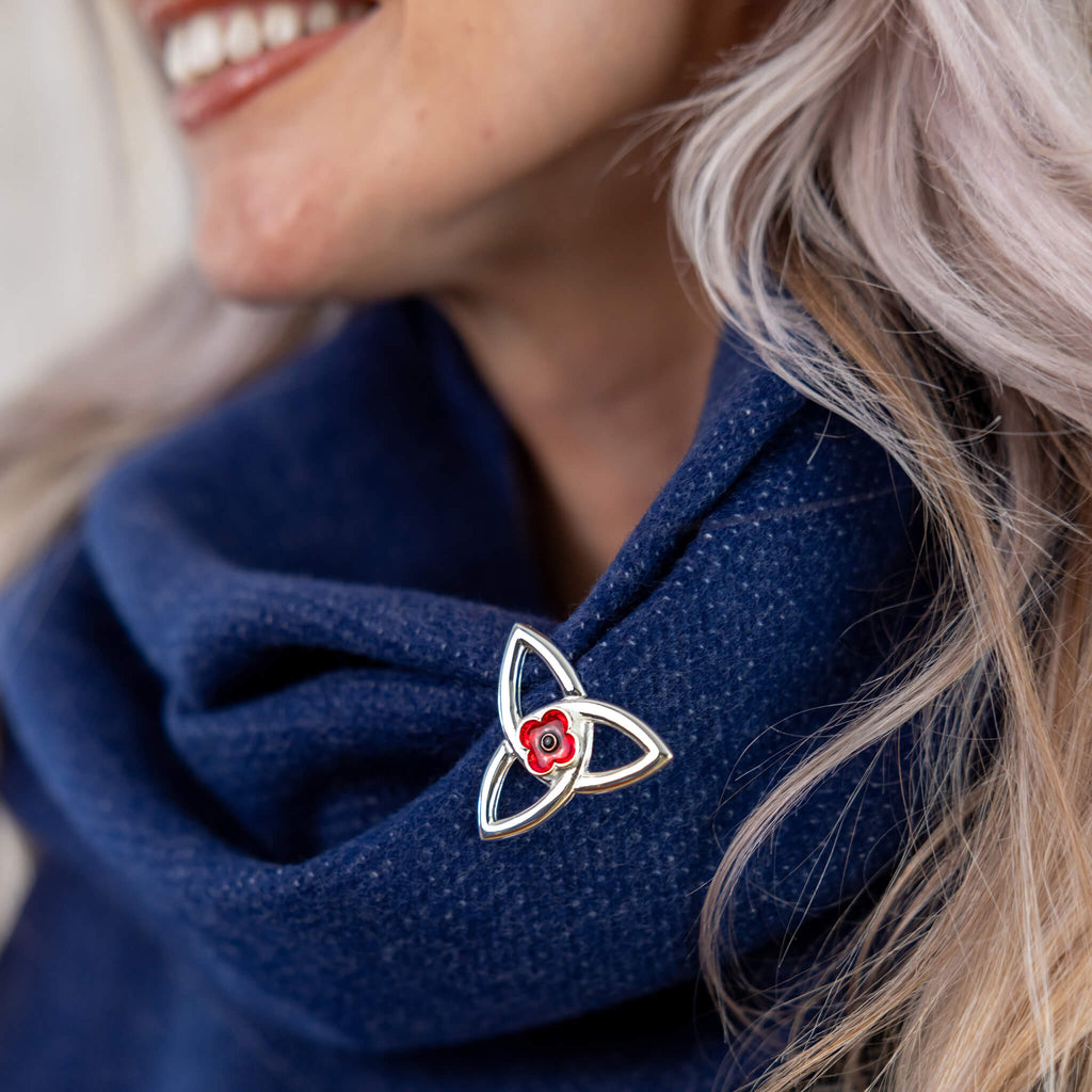 Woman with poppy brooch from the Poppyscotland jewellery Collection pinned to her scarf